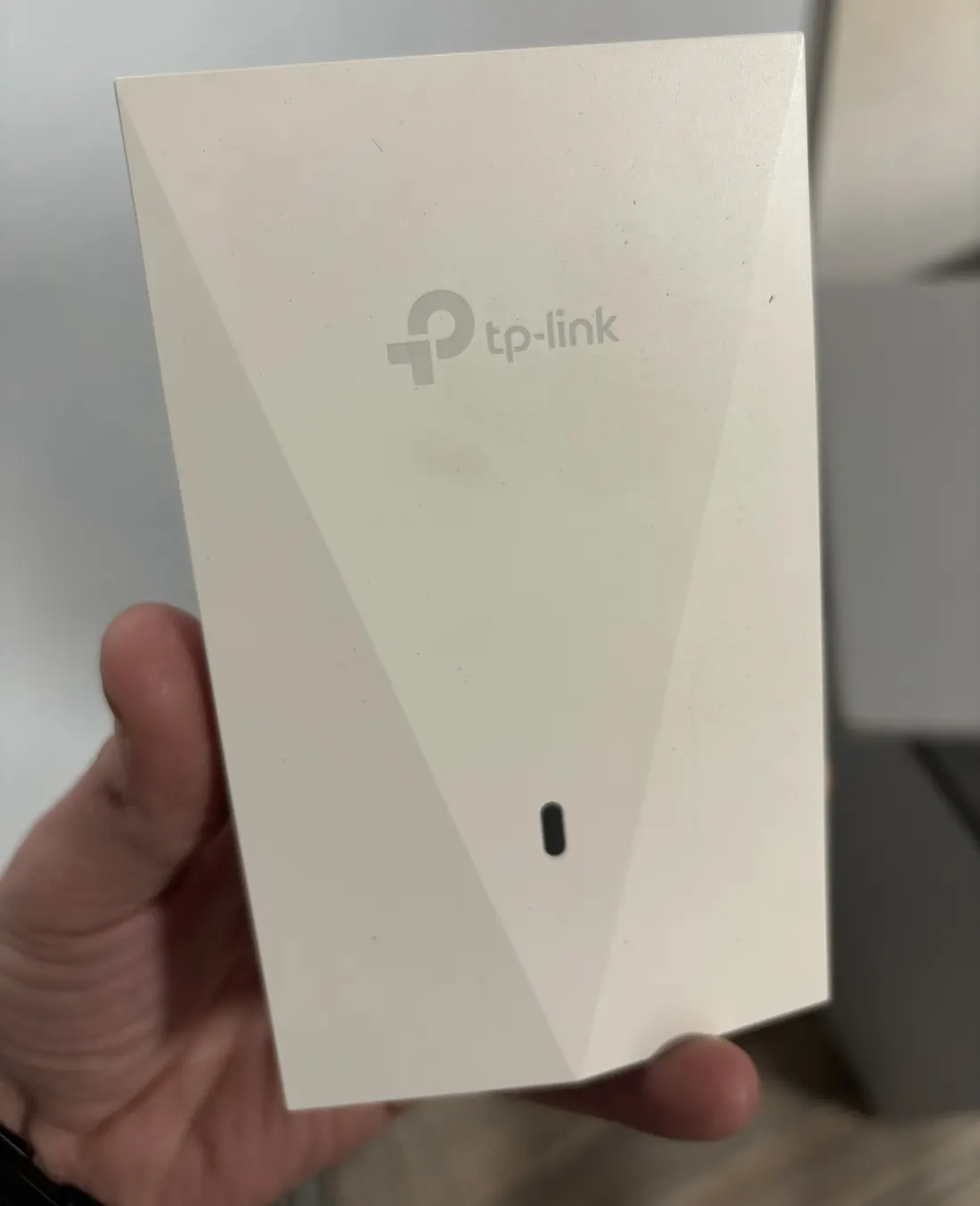 Access point de pared TP-Link sostenido en la mano