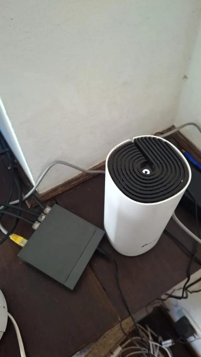 Nodo Deco de TP-Link junto a un switch pequeño